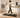 A remote worker walking on an under-desk treadmill at an adjustable standing desk in a bright home office.